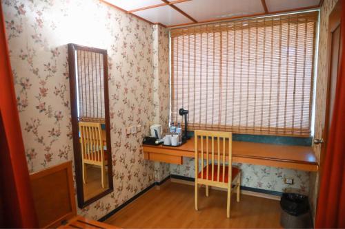a small room with a desk and two chairs at Bell Hotel in Sivakāsi