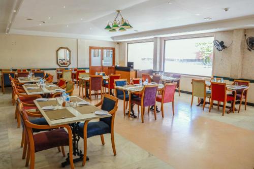 a restaurant with tables and chairs and a large window at Bell Hotel in Sivakāsi