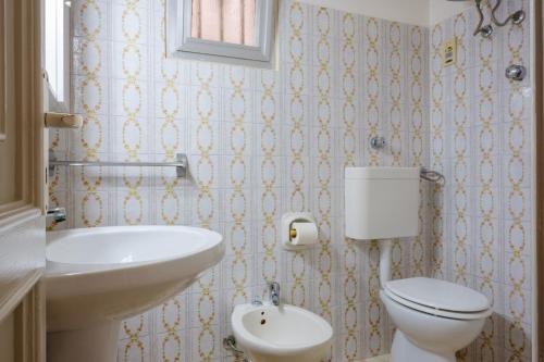 ein Badezimmer mit einem weißen WC und einem Waschbecken in der Unterkunft Casa Vacanza Maria in Casalabate