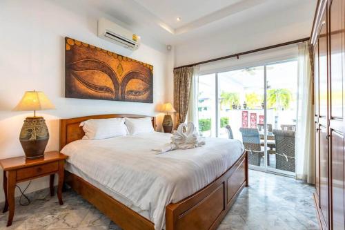 um quarto com uma cama e uma grande janela em Private 3 Bedroom Pool Villa PP10 em Hua Hin