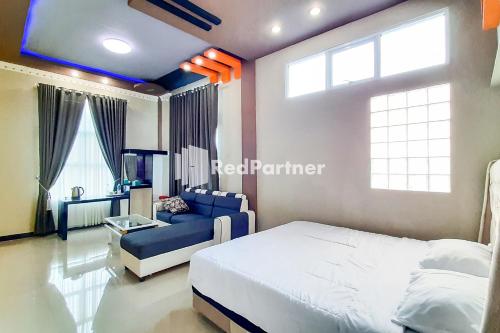 a bedroom with a bed and a blue couch at MT Syariah Homestay Kerinci RedPartner in Pondokpematangtanah