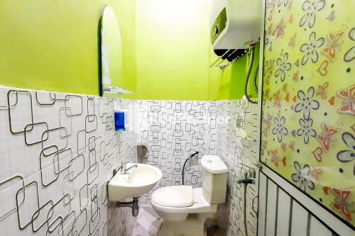 a bathroom with a toilet and a sink at MT Syariah Homestay Kerinci RedPartner in Pondokpematangtanah