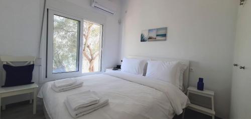 ネア・アンヒアロスにあるALBA OCEAN VIEW LUXURY RESIDENCEの白いベッドルーム(タオル付きのベッド付)