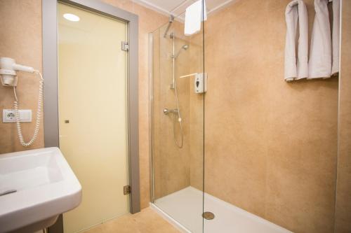 a bathroom with a glass shower and a sink at Hotel Oasis Plaza in Benidorm