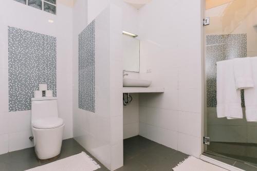a white bathroom with a toilet and a shower at Turtle Bay Dive Resort in Moalboal