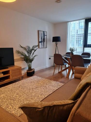 a living room with a couch and a flat screen tv at Stay Yorkshire I Quarter Apartment 53 in Sheffield