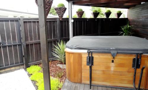 a hot tub in a backyard next to a fence at Aarburg Airport Motel in Christchurch