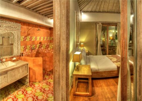 1 dormitorio con cama, lavabo y espejo en Villa Layla - Charming 2BR Villa in Oberoi - Prime Location!, en Seminyak