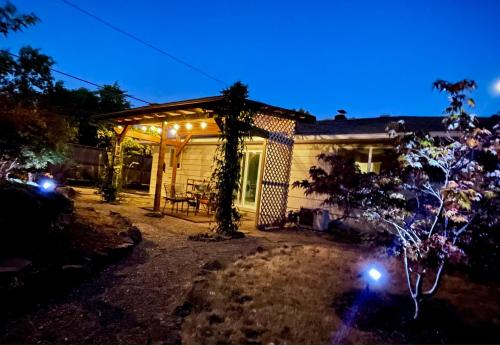 a backyard with a pergola at night with lights at Colorful 50's Ranch in the Heart of Eugene in Eugene