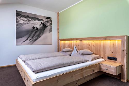 a bed in a room with a wooden wall at Hohenegg Apartment Franz 2 in Campolasta
