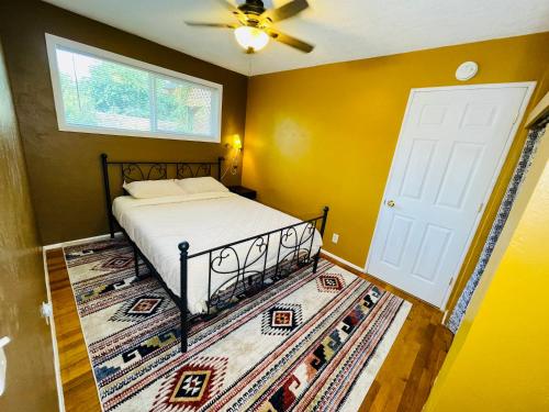 um quarto com uma cama e uma porta branca em Welcome! Colorful 50's Ranch in the Heart of Eugene em Eugene