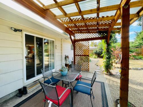 a patio with a table and chairs under a pergola at Colorful 50's Ranch in the Heart of Eugene in Eugene