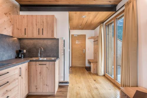 a kitchen with wooden cabinets and a large window at Hohenegg Apartment Karolina in Campolasta