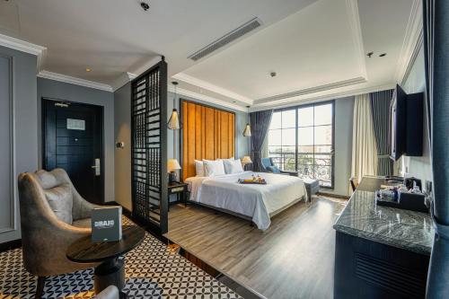 ein Hotelzimmer mit einem Bett und einem Stuhl in der Unterkunft Hôtel D’Melin in Vũng Tàu