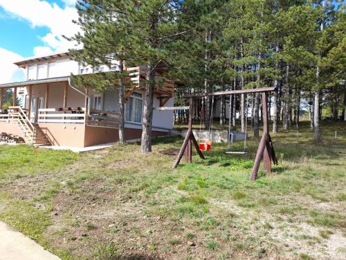 a house with a playground in front of it at Ruza vetrova in Divčibare