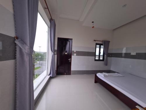 a room with a bed and a large window at Khách sạn Hoàng Mai in Ấp Thới Thuận (4)