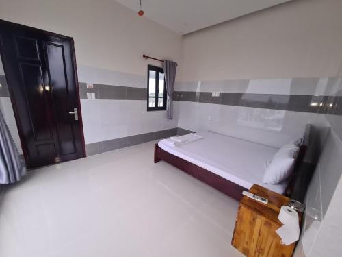 a small room with a bed and a window at Khách sạn Hoàng Mai in Ấp Thới Thuận (4)