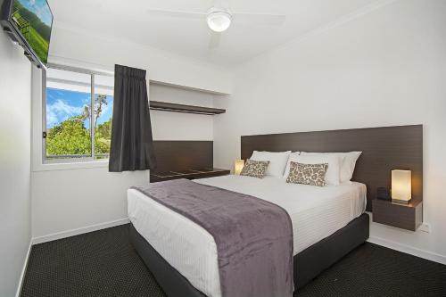 a bedroom with a large bed and a window at Cooroy Luxury Motel Apartments in Cooroy