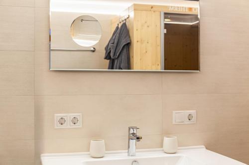 a bathroom with a sink and a mirror at Ferienwohnung Galerie Kaiser in Mayrhofen
