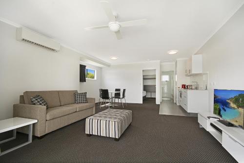 a living room with a couch and a table at Cooroy Luxury Motel Apartments in Cooroy