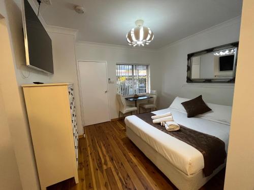 1 dormitorio con cama y lámpara de araña en Baths Motel Moree, en Moree