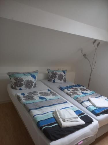 a bed with blue and white sheets and pillows at Hotel Wiesbadener Hof in Stuttgart