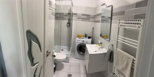 bagno bianco con lavandino e lavatrice di Luxury Mall Q4 Apartment a Bacău