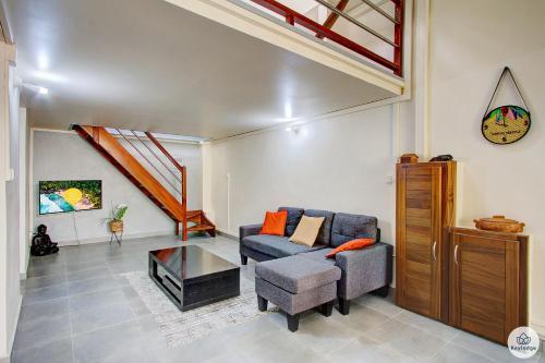 uma sala de estar com um sofá e uma mesa em Mauricia - Maison - 77m2 - Saint-Benoit em Saint-François