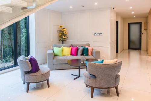 a living room with a couch with colorful pillows at ONE Hotel in Pathum Thani
