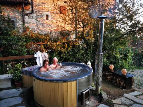 two people in a hot tub in a backyard at B&B con SPA il Castello di Lucawest in Ponteranica