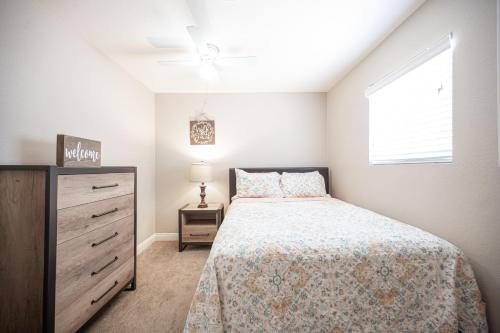 拉斯維加斯的住宿－Charming 2 Bedroom House，一间卧室配有一张床、一个梳妆台和一扇窗户。