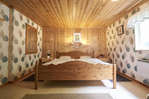 a bedroom with a bed in a wooden wall at Savolax Stugor in Axland