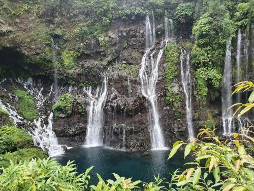 un grupo de cascadas a un lado de una montaña en ô Langevin , Logement avec véhicule, en Saint-Joseph