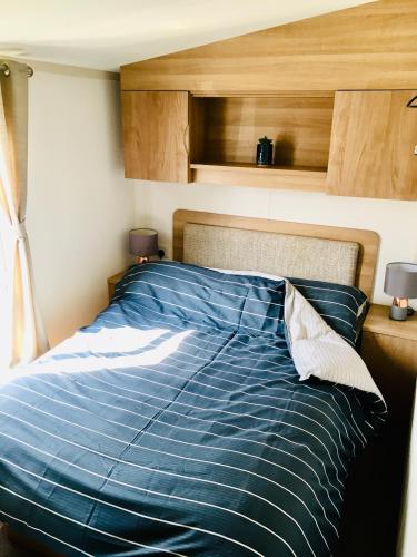 1 cama con edredón azul en un dormitorio en Jacobs Retreat- Lido Beach- well behaved dogs welcome, en Prestatyn