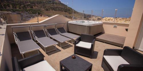 a balcony with chairs and a hot tub on a roof at Sciabika Home - Edificio Eolie in Castellammare del Golfo