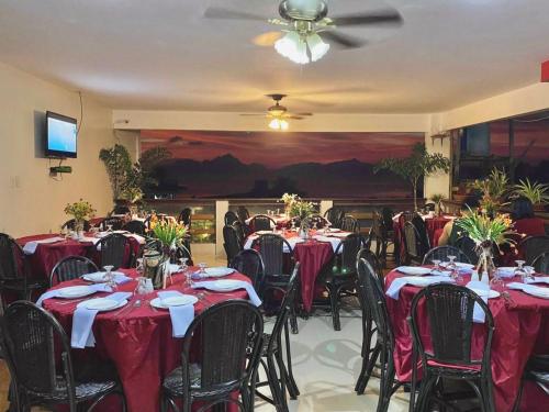 un salón de banquetes con mesas y sillas con manteles rojos en La Casa Teresa Tourist Inn Inc, en El Nido