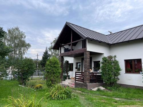 a white house with a black roof at Casa Helen Insurance&Tourism in Gălăuţaş