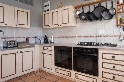a kitchen with white cabinets and a stove top oven at Fairhill Farm in Gansbaai