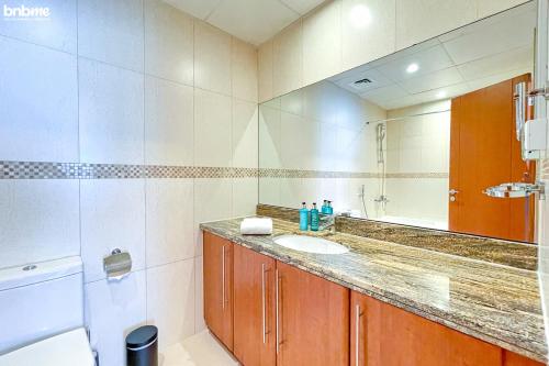 a bathroom with a sink and a mirror at bnbmehomes - Live & Work 'w' Style in 1B Apt - 3007 in Dubai