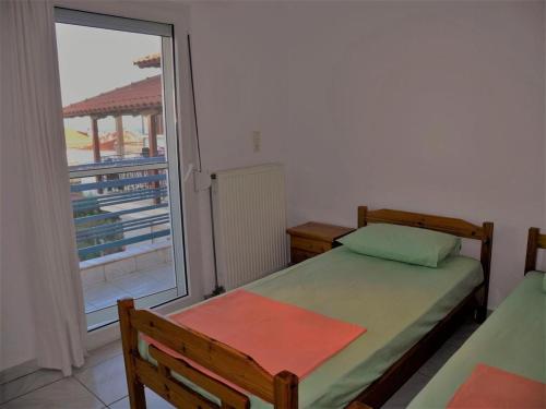 a bedroom with a bed and a large window at Vassilikos Apartment in Flogita