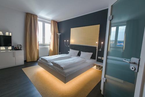 ein Schlafzimmer mit einem Kingsize-Bett in einem Zimmer in der Unterkunft Hotel Sinsheim in Sinsheim