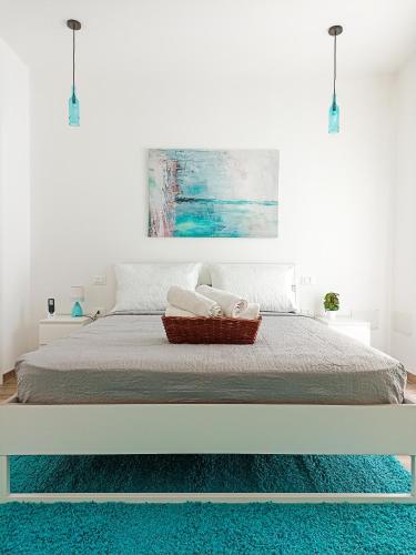 a white bedroom with a bed with a blue rug at Kolossoi Guest House in Càbras