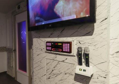 a tv on a wall with two wii remote controls at Geoje Mongdol Beach H Avenue Hotel in Geoje 