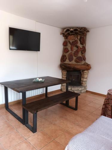 ein Wohnzimmer mit einem Tisch und einem Kamin in der Unterkunft Casas rurales La Trufa Madre Casa 3 in Vega del Cadorno