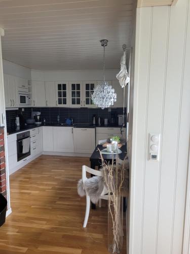 a kitchen with a table and a chandelier at Villa Myklebostad in Sand