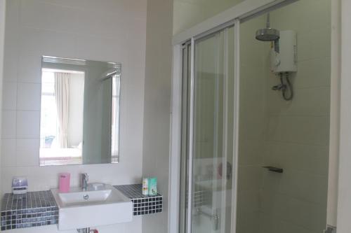 Un baño con ducha, lavabo y espejo. en Enjoy Krabi and Relax, en Klong Muang Beach
