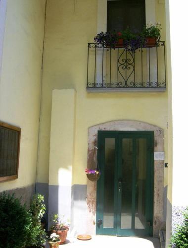 a building with a green door and a balcony at Il Minotauro B&B a 5 minuti da Popoli in Vittorito