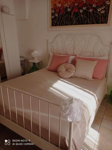 a bedroom with a bed with pink pillows at La loggetta 63 in Palagianello