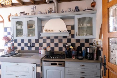 une cuisine avec des armoires blanches et un évier dans l'établissement Gite U fragnu di Peruccio, à Levie