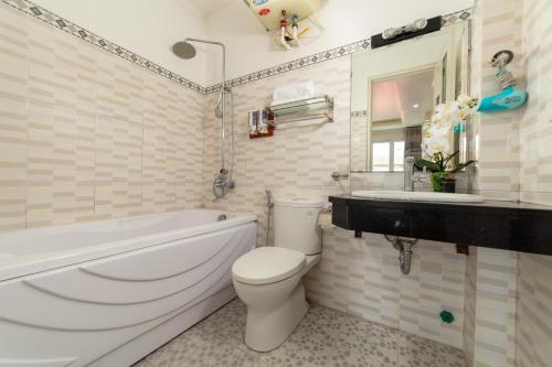 a bathroom with a tub and a toilet and a sink at Hanoi Delica Hotel in Hanoi